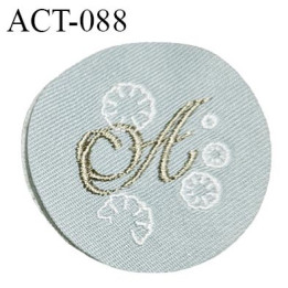 Ecusson patch à coudre accessoire décor ornement avec lettre A brodée en mordoré sur tissu vert de gris diamètre 43 mm