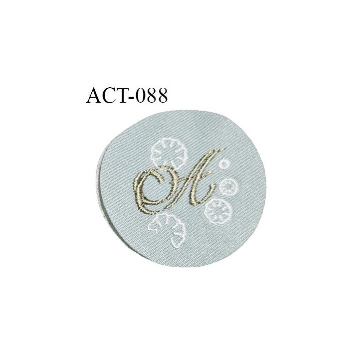 Ecusson patch à coudre accessoire décor ornement avec lettre A brodée en mordoré sur tissu vert de gris diamètre 43 mm